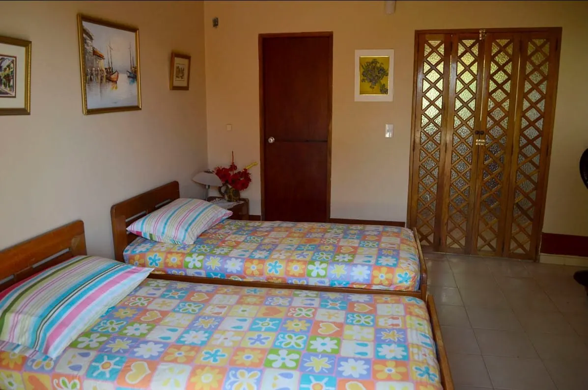 Habitación con dos camas sencillas y clóset de madera